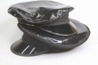 A black faux leather military style cap, together with another