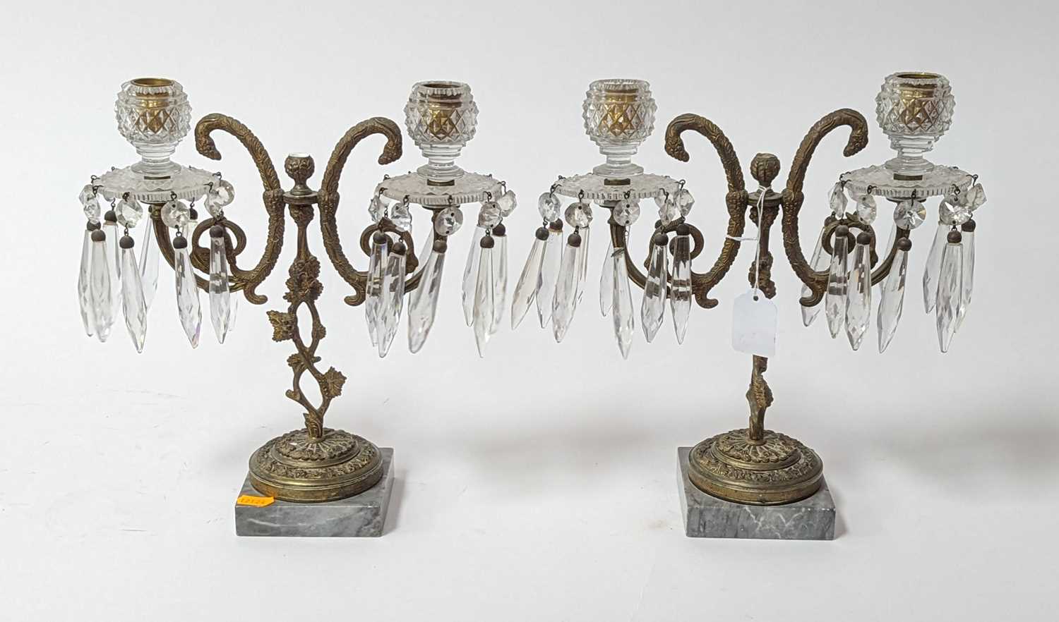 A pair of brass and cut glass table candlesticks, each in the form of fruiting vines upon a polished