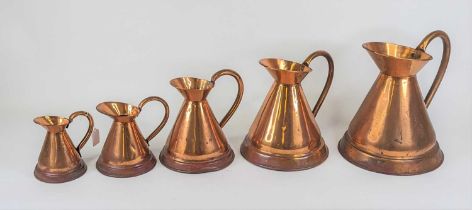 A graduated set of five copper jugs, largest 30cm high