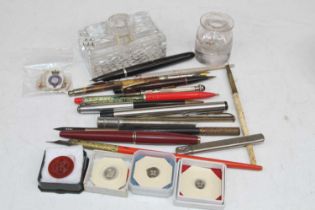 A collection of pens to include Parker example having a red lacquered cap and barrel, together