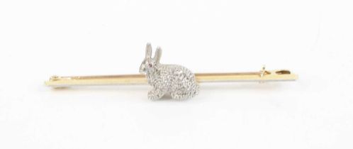 A 15ct gold and platinum bar brooch, surmounted with a small rough cut diamond set hare, having ruby