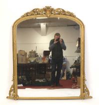 A Victorian giltwood and gesso overmantel mirror, the arched plate below an acanthus leaf and flower