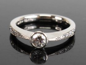 A platinum diamond solitaire ring, comprising a round brilliant cut diamond in a bezel setting, with