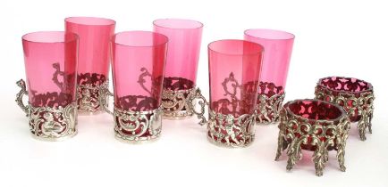 Three pairs of cranberry glass beakers in Edwardian silver sleeves, the sleeves of pierced single-