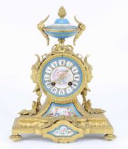 A late 19th century French gilt metal and porcelain mantel clock, the case surmounted with an urn,