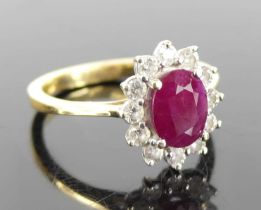 An 18ct yellow and white gold, ruby and diamond oval cluster ring, the centre ruby measuring