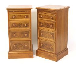 A pair of walnut and figured walnut bedside chests, each having cross and feather banded tops over a