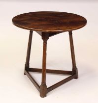 A George III oak cricket table having a planked top on ring turned supports, united by low square