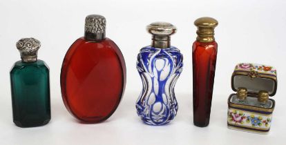 A collection of scent bottles, comprising an emerald glass and silver topped faceted rectangular