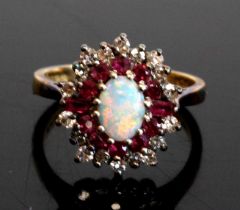 An 18ct yellow and white gold opal, ruby and diamond oval cluster ring featuring a centre opal