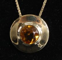 A 9ct yellow gold citrine circular target style pendant, having a round faceted citrine, approx