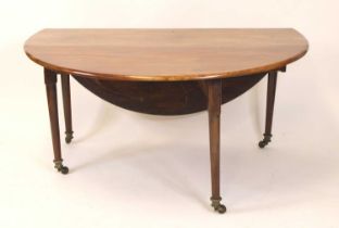 A George III mahogany dropleaf dining table, on turned and tapering gatelegs, with brass caps and