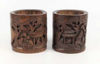 A pair of Chinese bamboo brush pots, 19th century, each carved with imortals viewing scrolls by a
