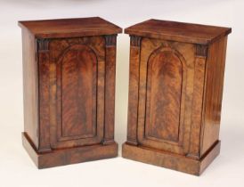 A pair of circa 1830 mahogany cupboards, each having recessed arched panelled doors enclosing