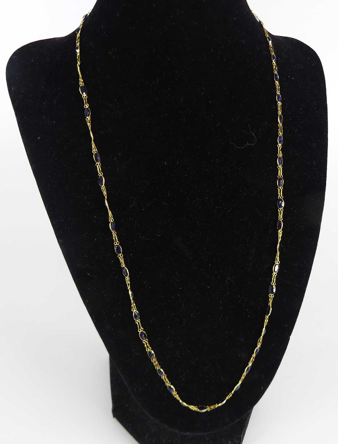 A yellow metal sapphire multi-stone necklace, comprising 49 oval sapphires in bezel setting, with