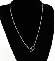 A white metal Cartier Love necklace, featuring two interlocking oval links with screw detail, one