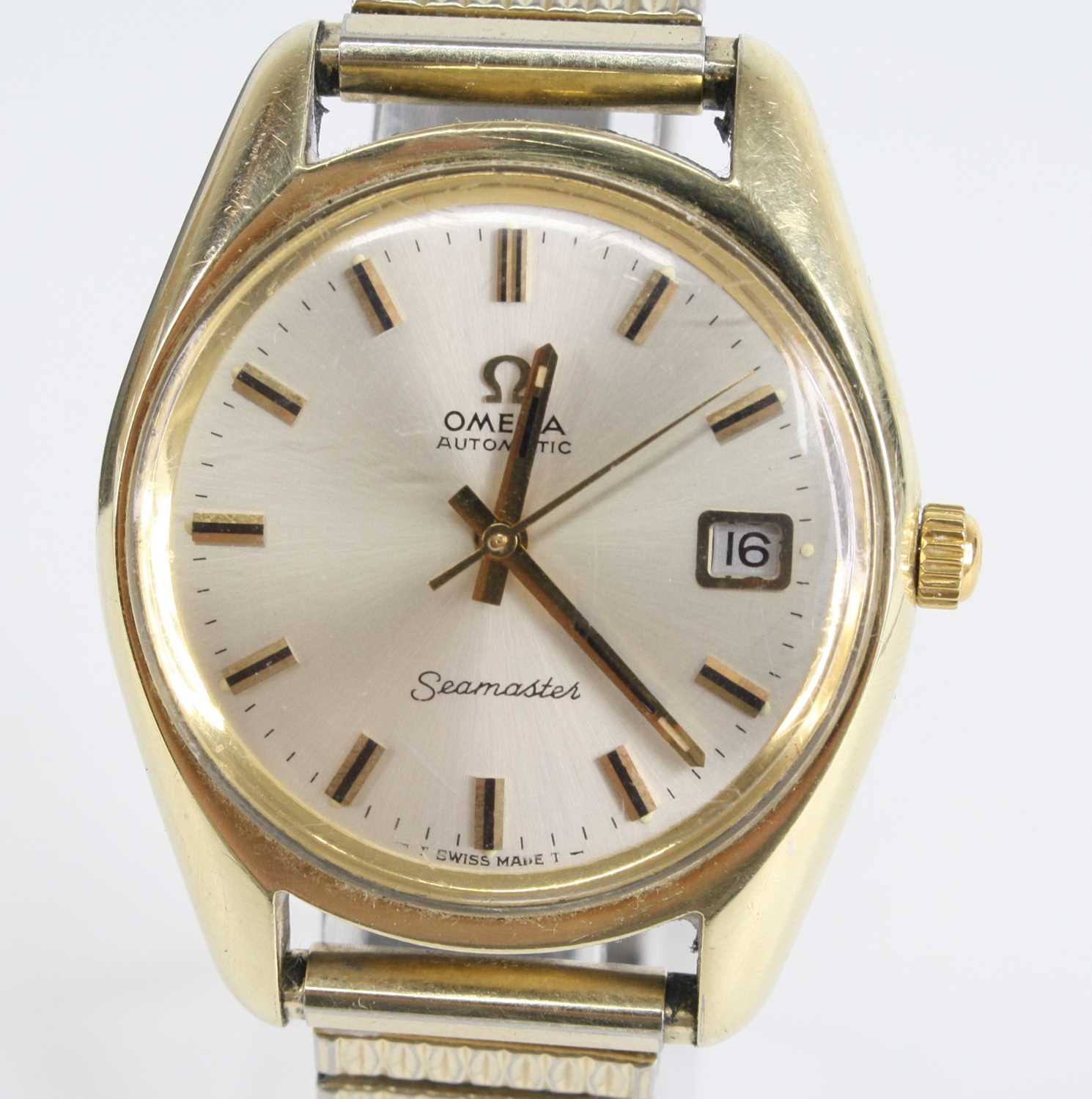 A gents Omega Seamaster gold-plated steel automatic watch, having a round silver baton dial with