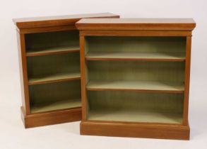A pair of Victorian style walnut and figured walnut open bookcases, each having cross and feather