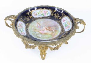A circa 1900 Sèvres style porcelain table bowl, housed in floral cast twin handled gilt metal