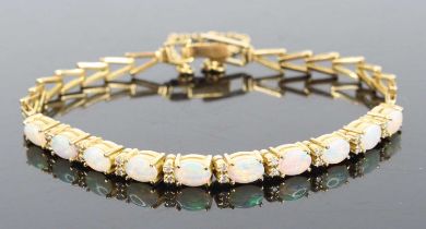 An 18ct yellow gold opal and diamond bracelet, comprising ten oval opal cabochons alternating with