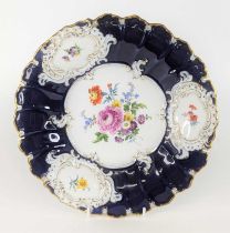 A Meissen porcelain cabinet plate, enamel decorated with flowers within a blue and gilt border,