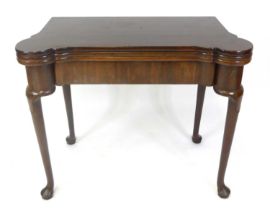 A mid-18th century 'red walnut' triple leaf fold-over card table, having a gamesboard top with
