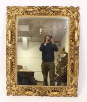 An 18th century continental gilt wood and gesso picture frame having later inset but early mirror