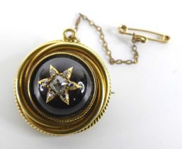 A late Victorian yellow metal target style garnet and diamond memorial brooch, comprising a round