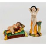 A Staffordshire pearlware figure of a sleeping child, early 19th century, shown with flowers upon