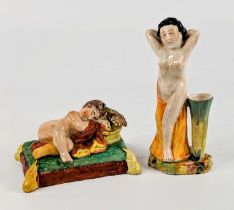 A Staffordshire pearlware figure of a sleeping child, early 19th century, shown with flowers upon