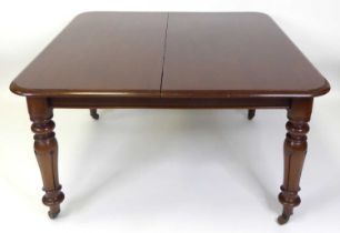 A mid-Victorian mahogany round cornered extending dining table, having pull-out action, two extra