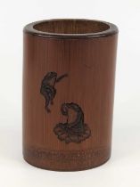 A Chinese bamboo brush pot, 19th century, carved with toads, peonies and foliage, h.15cm