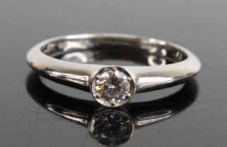 A platinum diamond solitaire ring, having a round brilliant cut diamond ina claw and bezel