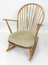 An Ercol blond elm stickback rocking elbow chair, model No. 315, with typical dished seat, w.73.5cm