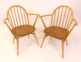 A pair of 1960s Ercol blond elm model 370A stickback elbow chairs, each on turned tapering supports,