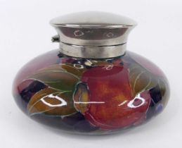 An early 20th century Moorcroft Pomegranate pattern pottery squat inkwell, with silver plated