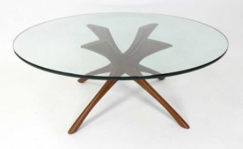 A 1960s Danish teak and heavy clear glass topped circular coffee table, raised on shaped and