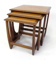 A 1960s G-Plan teak 'Fresco' nest of three occasional tables, raised on curved U-shaped end supports