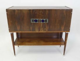 A 1970s Danish rosewood double door side cupboard, the doors inlaid with stylised tiles, raised on a