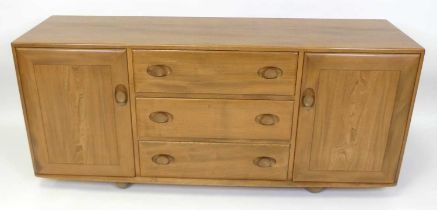 An Ercol blond elm Windsor sideboard, model No. 455, having three central drawers flanked by