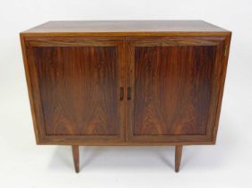 A 1960s Danish rosewood double door side cupboard, the interior compartments each with single