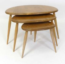 An Ercol blond elm 'Pebble' nest of three occasional tables, model No. 354, each of shaped form