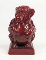 Bernard Moore (1850-1935) - a red flambé glazed pottery model of a monkey, shown squatting, BM