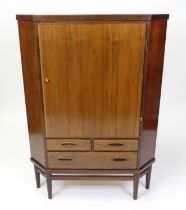 A 1960s Danish rosewood corner cupboard, the single upper door enclosing twin fixed shelved interior