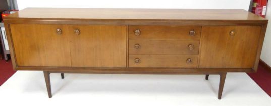 Ernest Gomme for G-Plan - a 1960s walnut long sideboard, having three drawers, twin cupboard