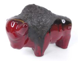 A flambé volcanic glazed model of a standing bison, of stylised form, unsigned, length 31.5cm