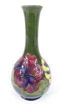 An early 20th century Moorcroft Hibiscus pattern pottery vase, the elongated stem over lower