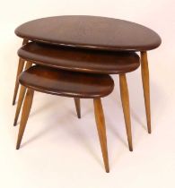 An Ercol dark elm nest of three 'Pebble' occasional tables, model No. 354, each on turned tapering