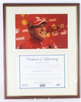 Michael Schumacher, a 19.5 x 29.5cm colour photograph signed in black ink mid right, mounted with