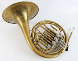 A 20th century brass French horn, marked KMI Lewington, London, in fitted travel case. Brass is